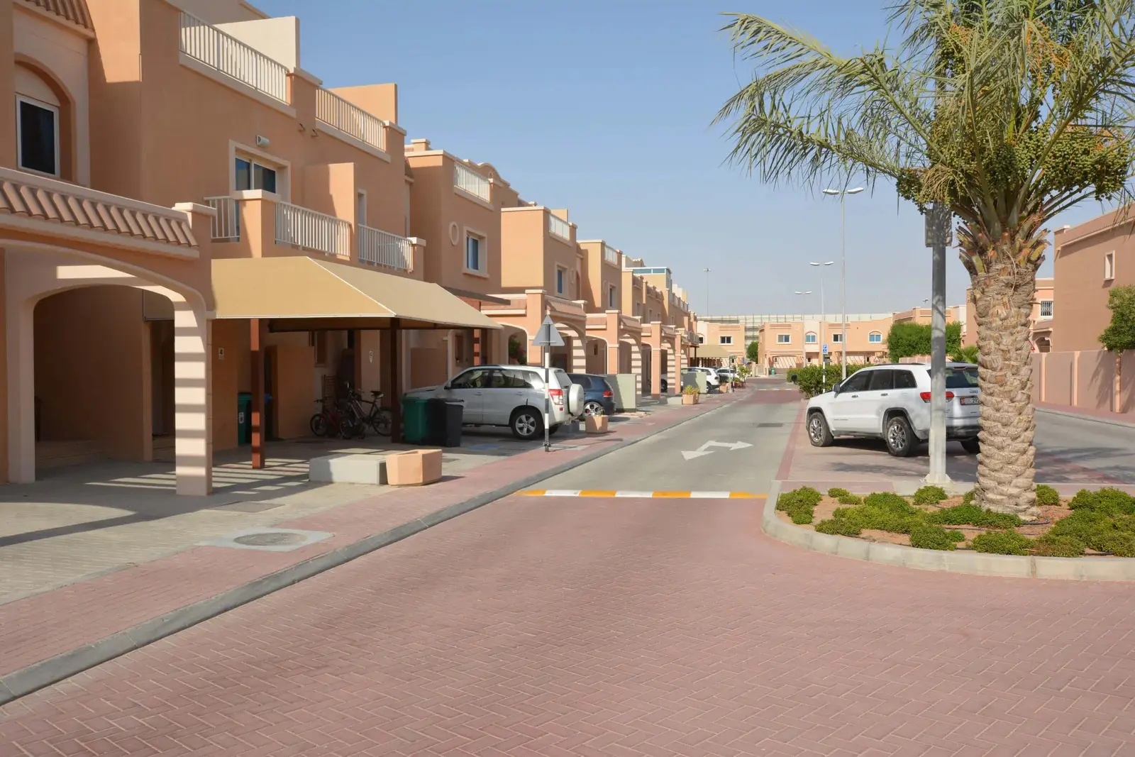 Community swimming pool with sun loungers, shaded areas, and clear blue water at Abu Dhabi